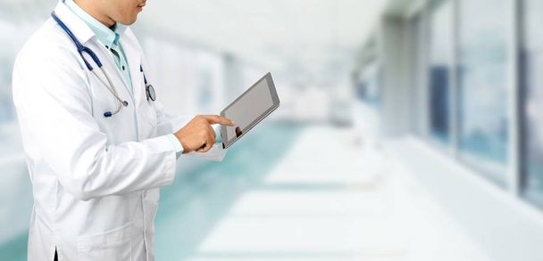Male doctor using tablet computer at hospital. Medical research staff and doctor service. - Photo, Image