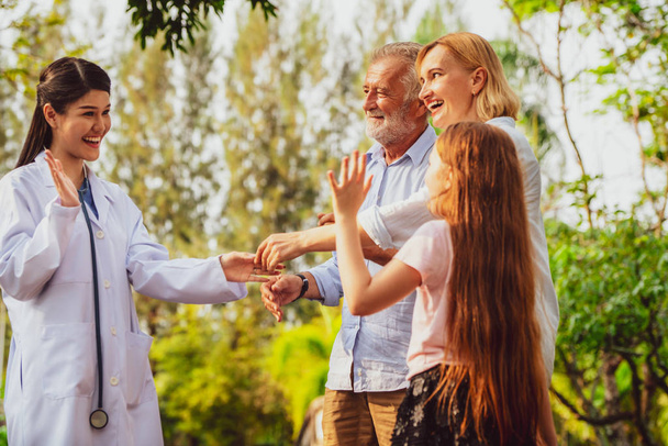 Happy healthy family and doctor talking in the park. People healthcare and medical staff service concept. - Photo, Image