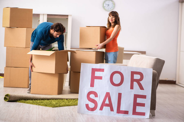 Genç bir aile satılık ev teklif ediyor ve taşınıyor. - Fotoğraf, Görsel