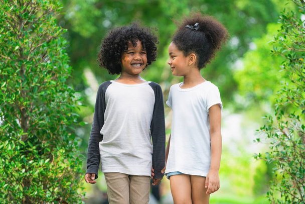 Onnellisia pikkupoikia ja tyttöjä puistossa. Kaksi afroamerikkalaista lasta puutarhassa.
. - Valokuva, kuva