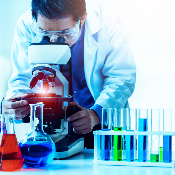 Lääketieteellisessä laboratoriossa työskentelevä mies, joka tutkii biokemian näytettä mikroskoopilla. Tiede teknologia lääketiede tutkimus ja kehittäminen tutkimus käsite
. - Valokuva, kuva