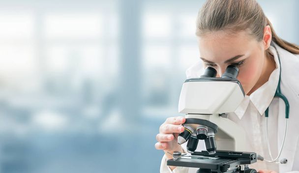 科学者の研究者が研究室で顕微鏡を用いたします。医療の医療技術や医薬品の研究・開発のコンセプト. - 写真・画像