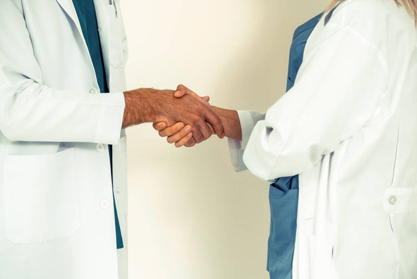 GP doctor shake hand with surgical doctor on white background. - Foto, Imagem