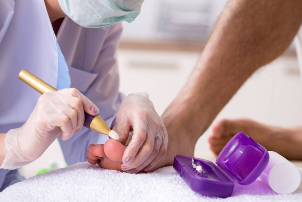 Podólogo tratando los pies durante el procedimiento - Foto, Imagen