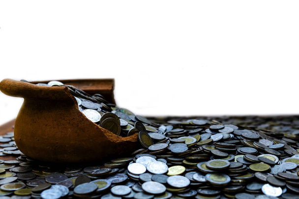 Empilement de pièces de monnaie dans un bocal au trésor sur bois avec fond blanc, pile d'argent pour l'investissement de planification d'entreprise et l'épargne concept futur
 - Photo, image