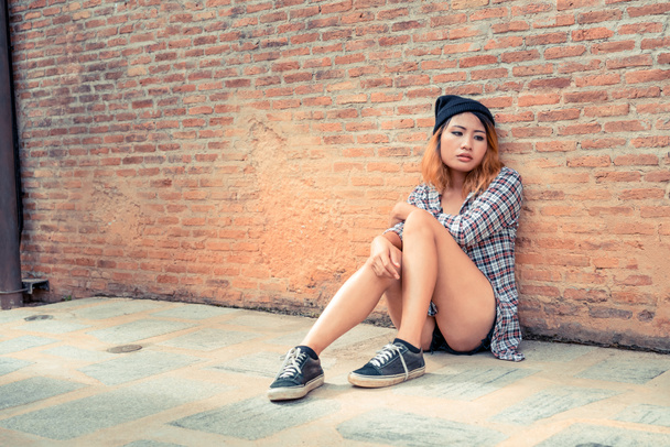 Adolescente déprimée se sentant triste seule contre un mur de briques dans la vieille ville. Concept d'éducation et d'échec familial
. - Photo, image