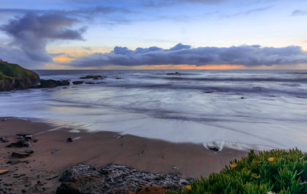 Пастельные цвета заката и шелковистой воды от длительного воздействия волн, ударяющихся о берег у маяка Pigeon Point на побережье северной Калифорнии в Тихом океане около Пескадеро
 - Фото, изображение