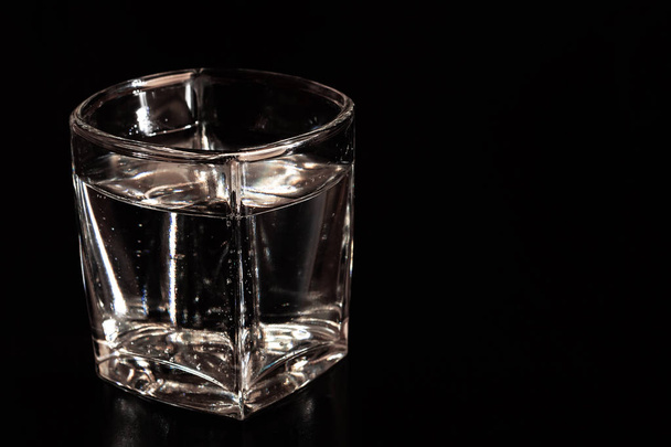 Vidrio con agua mineral con burbujas sobre fondo negro
 - Foto, Imagen