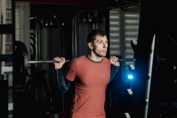 Handsome athletic man doing a squat in the gym. - Fotoğraf, Görsel