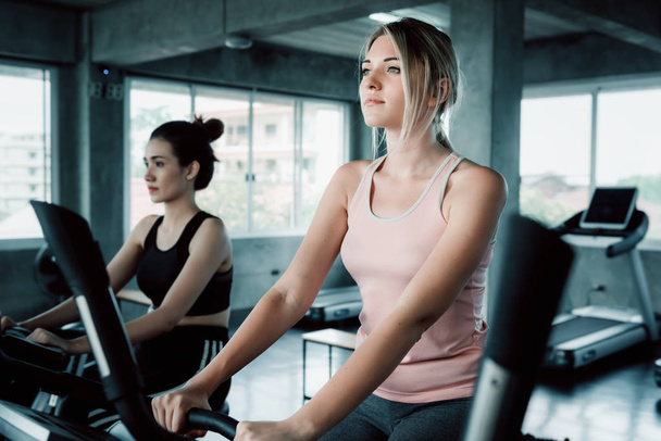 Women workout cycling exercise in fitness gym., Portrait of pretty caucasian woman is cycling training in gym., Sport club and healthy concept. - Foto, Imagem