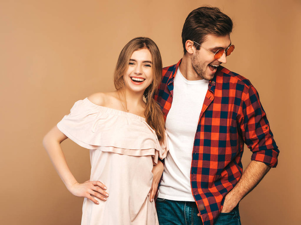 Portrait of Smiling Beautiful Girl and her Handsome Boyfriend laughing.Happy Cheerful Family. in sunglasses.Valentine's Day. Posing on beige wall. Hugging - Φωτογραφία, εικόνα