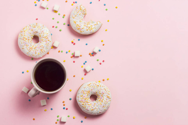 Cup of coffee, Fresh tasty sweet donuts on a pink background. The concept of fast food, bakery, breakfast, sweets. Minimalism. Flat lay, top view, copy space - Foto, afbeelding