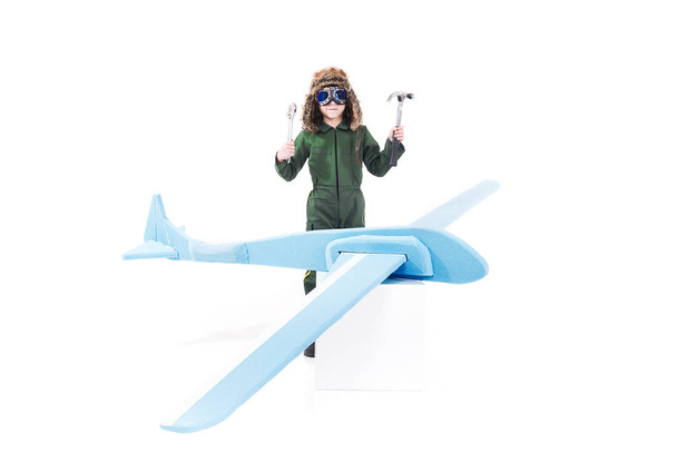 Carino ragazzo creativo con artigianale giocattolo aereo di legno che gioca per essere meccanico
 - Foto, immagini