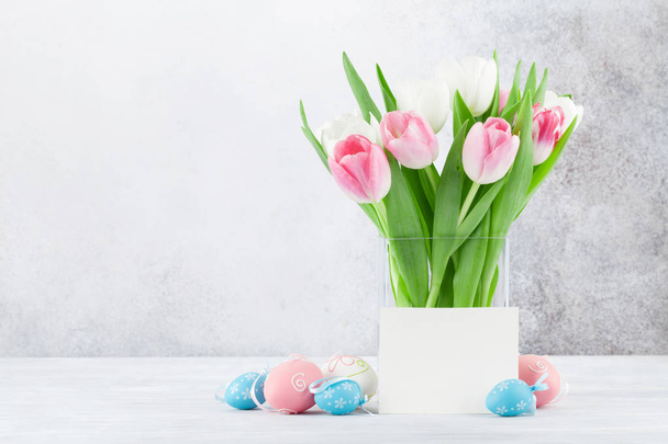 Pasen-wenskaart met tulp bloemen, gingerbread koekjes en paaseieren. Voor stenen muur met ruimte voor uw groeten - Foto, afbeelding
