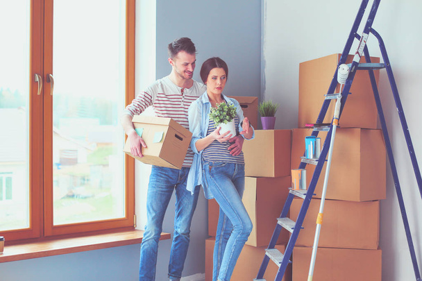 Happy young couple unpacking or packing boxes and moving into a new home. - 写真・画像