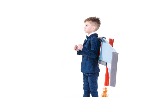 Cute ambitious little kid in suit getting ready to fly with jet pack wings - 写真・画像