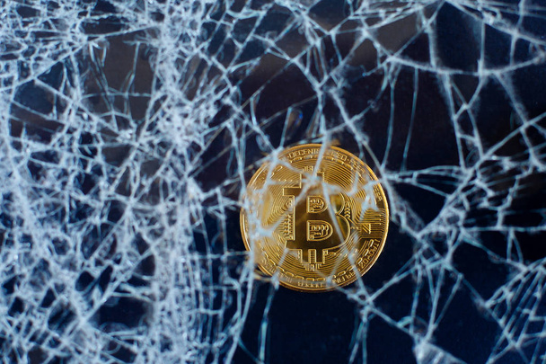 Bitcoin und zerbrochenes Glas auf schwarzem Hintergrund. Der Fall des Bitcoin. Crash-Kollaps - Foto, Bild