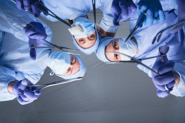 Surgeons team, woman wearing protective uniforms,caps and masks. - 写真・画像