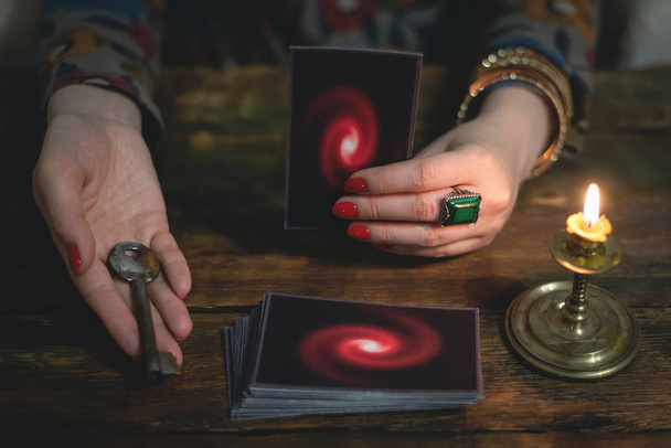 Tarot cards and a woman fortune teller with a unravelling key of fate. Future reading concept. Divination. - Foto, Bild