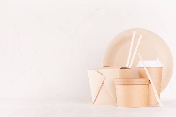 Blank different cardboard packaging for fast food - bowl, drink cup, box for noodles, cutlery, chopsticks, plate on white wood shelf, copy space. - Photo, Image