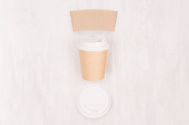 Ribbed coffee kraft paper cup with blank label, cap on light wood board, top view. Mockup for branding identity, advertising and design concept. - Foto, Bild