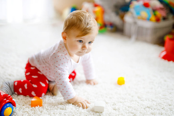 Suloinen söpö kaunis pieni vauva tyttö leikkii koulutuksellinen puinen leluja kotona tai lastentarha. Terve onnellinen lapsi värikkäällä punaisella autolla sisätiloissa. lapsen oppiminen värit ja muodot
 - Valokuva, kuva