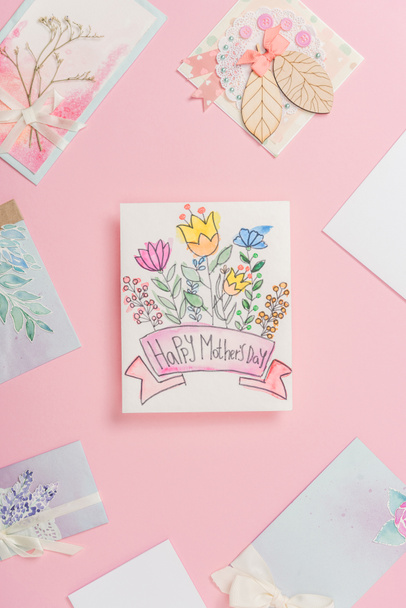 feliz día de las madres tarjeta de felicitación con flores, y diferentes postales del día de las madres dispuestas en torno a fondo rosa
 - Foto, Imagen