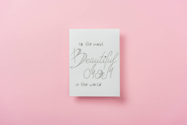 tarjeta de felicitación blanca para el día de las madres con "a la mamá más hermosa del mundo" texto escrito a mano sobre fondo rosa
 - Foto, imagen