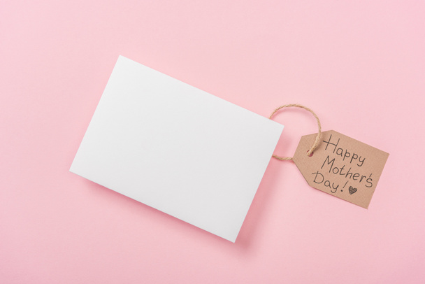 postal en blanco y etiqueta de madera con texto de saludo feliz día de las madres sobre fondo rosa
 - Foto, imagen