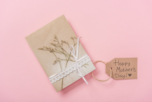mothers day greeting card decorated with dried plant and lace ribbon, with happy mothers day greeting text on pink background - Photo, Image