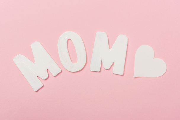 weißes Papierwort Mama und Papierherz auf rosa Hintergrund - Foto, Bild