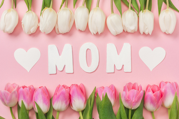 weiße und rosa Tulpen, Papierwort Mama und Papierherzen auf rosa Hintergrund - Foto, Bild