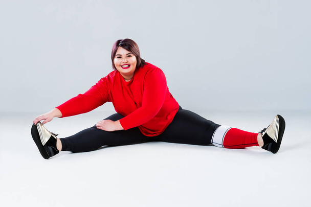 Plus size model in sportswear, fat woman doing workout on gray background, overweight female body, healthy lifestyle concept - Φωτογραφία, εικόνα