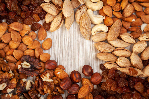 Peeled  almonds, raisins, apricot stone, walnuts, cashew,  hazelnut   pattern. Macro background texture of from a variety of nuts - Photo, Image