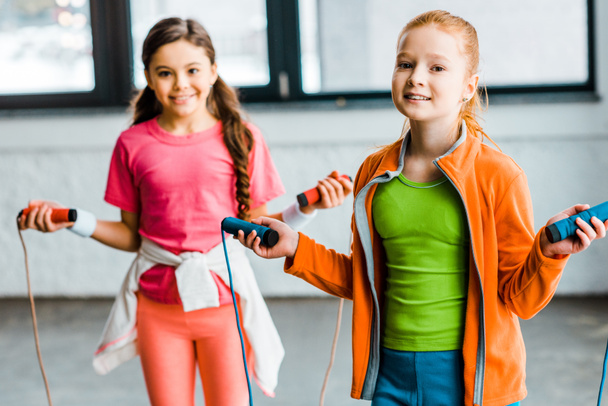 Happy children posing with skipping ropes in gym - Photo, Image
