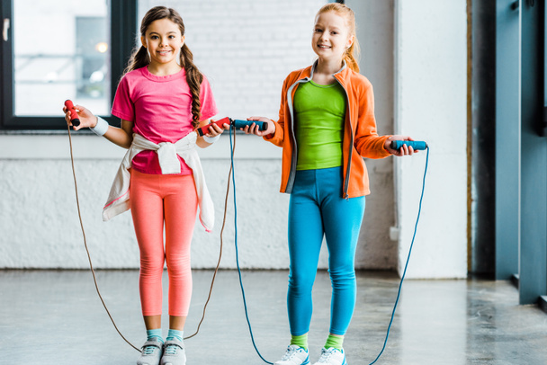 Adorables niños entrenando con cuerdas de saltar en el gimnasio
 - Foto, Imagen