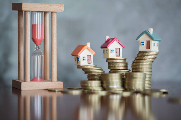 Huis model boven aan de stapel geld als de groei van het hypothecair krediet, Concept van beheer van onroerend goed. Invesment en risicobeheer. - Foto, afbeelding