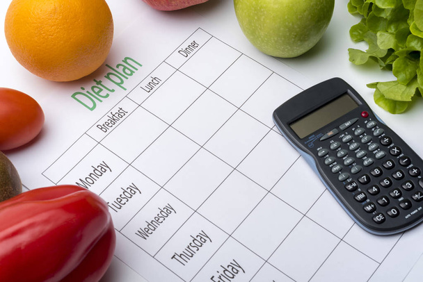 Diet plan sheet and fresh food on white background. Top view, the concept of healthy eating. - Photo, Image