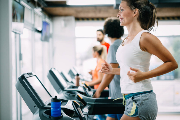Group of friends exercising on treadmill machine in gym - Zdjęcie, obraz