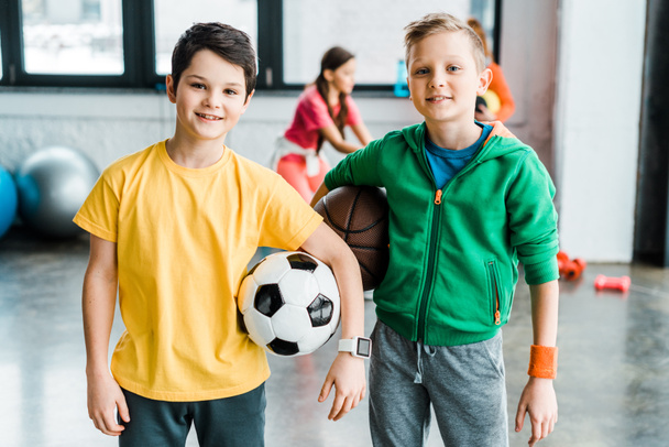 Smiling boys holding balls and looking at camera - Fotoğraf, Görsel