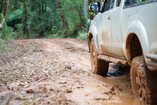  Voiture tout-terrain sale, VUS recouvert de boue sur route de campagne, pneus tout-terrain, voyage tout-terrain et concept de conduite
. - Photo, image