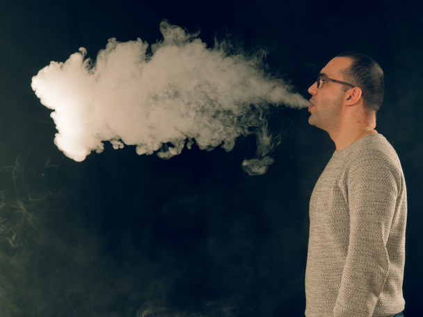 nuori mies tupakointi sähköinen savuke - Valokuva, kuva