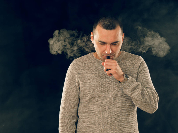 jonge man roken elektronische sigaret - Foto, afbeelding