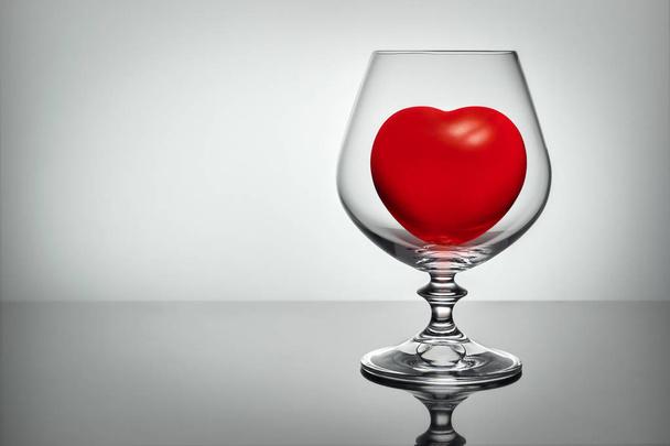 Red heart in transparent glass, concept love alcogol - Foto, afbeelding