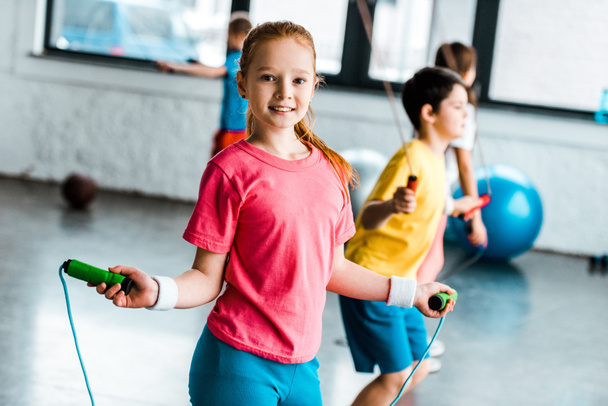 Preteen kids jumping with skipping ropes in gym - Photo, Image