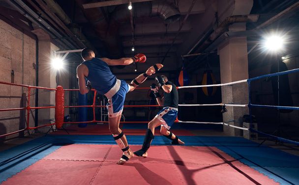 Zwei Sportler kickboxen im Ring beim Sportverein - Foto, Bild