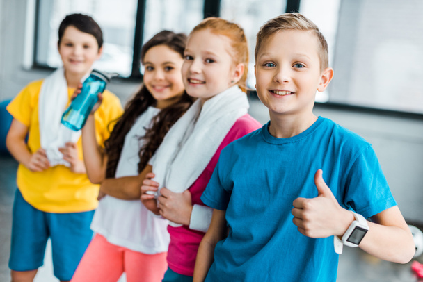 Enfants souriants avec des serviettes posant après l'entraînement en salle de gym
 - Photo, image