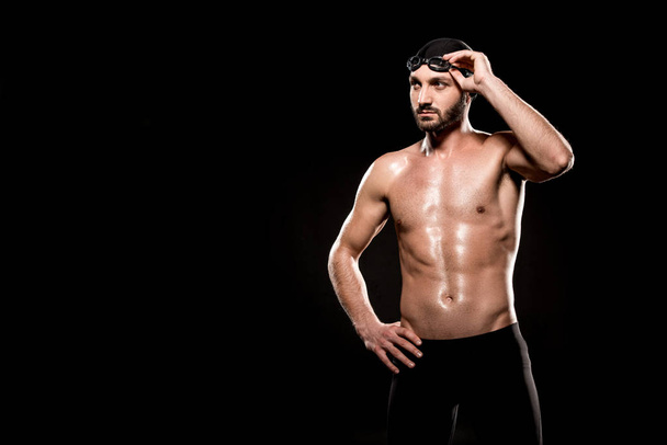 izmos úszó állt úszósapka és megható úszás védőszemüveg elszigetelt fekete - Fotó, kép