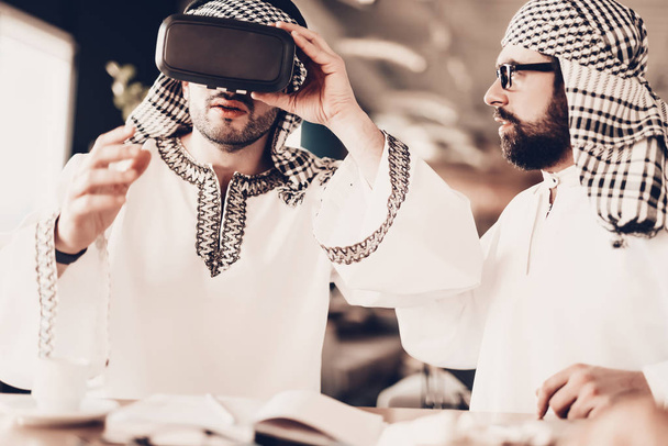 Arabs Businessman. Men Wearing in white clothes. Experienced Entrepreneur. Successful Young Man. Portrait of Arab. Good Leisure. Arab with glasses. looks at VR glasses. looking at friend - Photo, Image