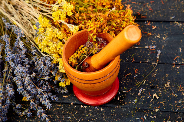 Parantaminen yrttejä puinen musta pöytä, kasviperäisiä lääkkeitä. tutsan, sagebrush, oregano, helichrysum lavender
 - Valokuva, kuva